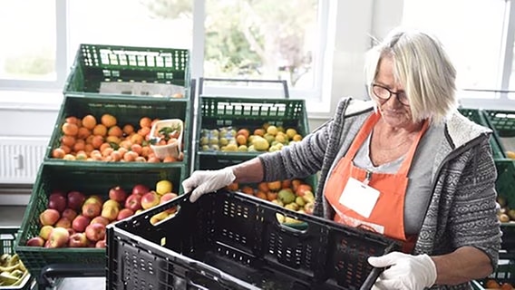 Eine Mitarbeiterin der Tafel bei der Essenausgabe. © Tafel Deutschland e.V. Foto: Reiner Pfisterer