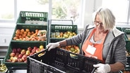 Eine Mitarbeiterin der Tafel bei der Essenausgabe. © Tafel Deutschland e.V. Foto: Reiner Pfisterer