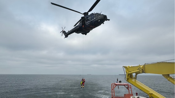 Eine Einsatzkraft der Feuerwehr Rostock wird vom Bundespolizeihubschrauber „Super Puma“ auf die BALTIC abgeseilt. © Havariekommando 