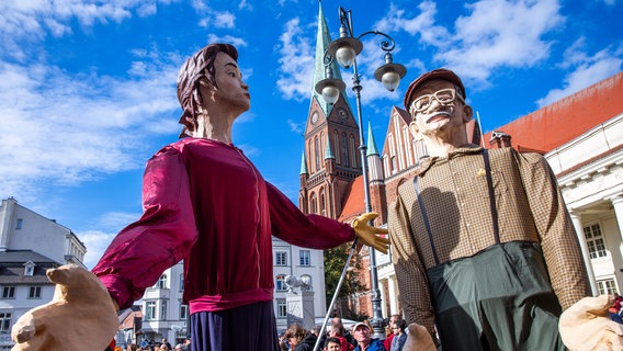 Große Puppen sind auf dem Marktplatz bei der Eröffnung der Feierlichkeiten zum Tag der Deutschen Einheit unterwegs. © dpa Foto: Jens Büttner