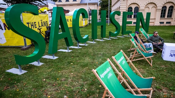 Wenige Besucher halten sich auf dem Länderbereich des Freistaates Sachsen für die Feierlichkeiten zum Tag der Deutschen Einheit auf. © dpa Foto: Jens Büttner