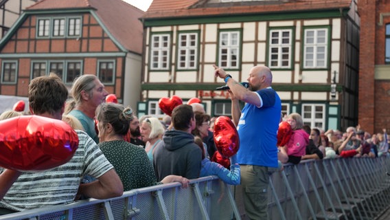 Stefan Kuna steht auf der Absperrung und zählt Besucher. © NDR 1 Radio MV Foto: Jan Baumgart