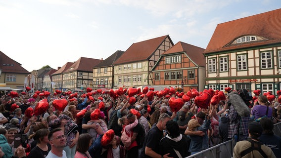 Viele Menschen mit roten Herzballons auf dem Marktplatz in Grabow. © NDR 1 Radio MV Foto: Jan Baumgart