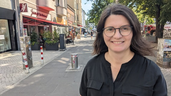 EIne Frau in dunkler Bluse blickt lächelnd durch ihre Brille in die Kamera. © NDR Foto: Katja Bülow