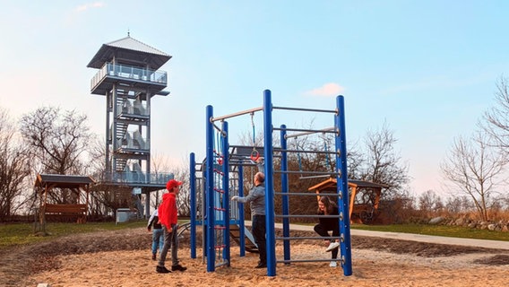 Der Aussichtsturm in der Gemeinde Liepgarten mit spielenden Kindern im Vordergrund. © Amt am Stettiner Haff 