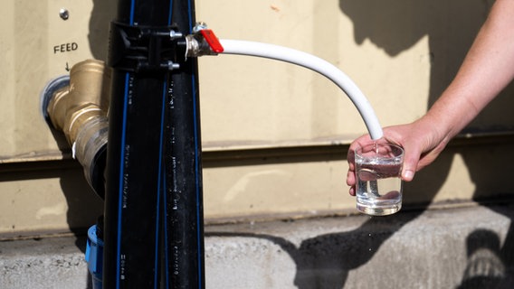 Ein Mann füllt an einer Meerwasserentsalzungsanlage der Firma Boreal Light Trinkwasser in ein Glas. © picture alliance/dpa Foto: Sebastian Gollnow