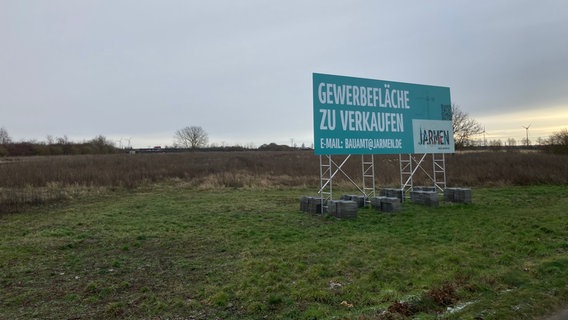 Die Fläche für den zukünftigen Gewerbepark in Jarmen samt Werbeschild dafür. © NDR Foto: Susann Moll