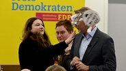 Der FDP-Vorsitzende Christian Lindner bekommt bei einem Wahlkampfauftritt in Greifswald von der Linke-Lokalpolitikerin Christiane Kiesow (l) Schaum ins Gesicht geworfen. © Stefan Sauer 