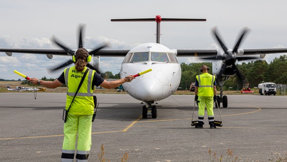 Auf dem Bild sind zwei Fluglotsen vor einem Flugzeug auf dem Flughafen Heringsdorf zu sehen. © Flughafen Heringsdorf Foto: Fabian Lührs