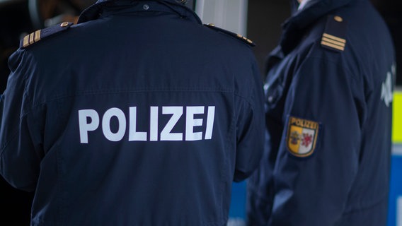 Polizisten der Landespolizei Mecklenburg-Vorpommern stehen vor einem Polizeifahrzeug. © Jens Büttner/dpa-Zentralbild Foto: Jens Büttner