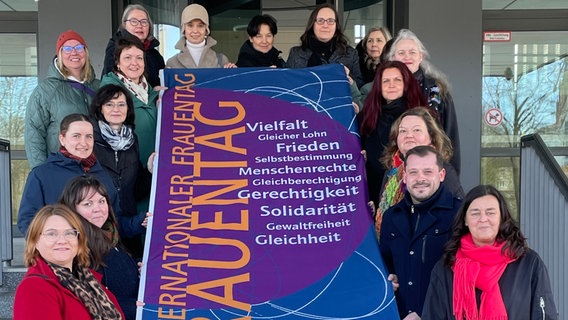 Unterstützerinnen mit eine Flagge auf den Rathaustreppen Neubrandenburg © Stadt Neubrandenburg 