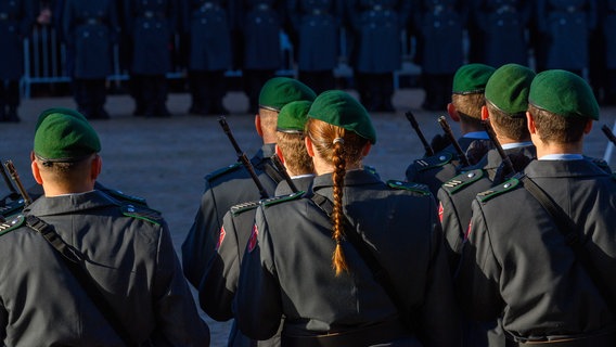 Sonnenlicht fällt beim feierlichen Gelöbnis der Bundeswehr auf einem Markplatz auf Soldaten und Soldatinnen der Ehrenformation. Im Hintergrund sind Rekruten und Rekrutinnen der Bundeswehr zu sehen. (Themenbild) © dpa-Bildfunk Foto: Klaus-Dietmar Gabbert