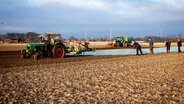 Landwirte bedecken ein Feld mit einer Folie, nachdem dort zuvor vorgekeimte Kartoffeln gesetzt wurden, um sie vor Witterungseinflüsse zu schützen. (Themenbild) © picture alliance/dpa Foto: Moritz Frankenberg