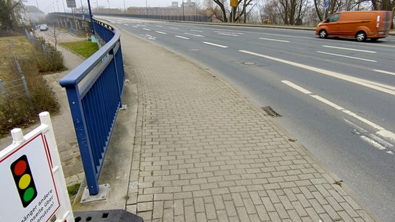 Die Wismarer Hochbrücke im Nebel. Unten in der linken Bildecke ist ein Schild zu sehen, wonach man den anderen Bürgersteig nutzen soll. © NDR Foto: Christoph Woest