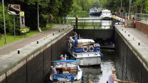 Mehrere Motorboote fahren in die Eldekanal-Schleuse von Lübz (Landkreis Parchim). © Jens Büttner 