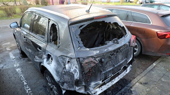 Auf einem Parkplatz steht ein Auto mit ausgebranntem Heck © Stefan Tretropp Foto: Stefan Tretropp