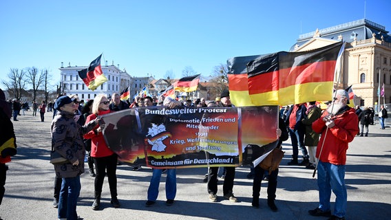 Teilnehmer eines Demonstrationszuges tragen Deutschland-Fahnen und Plakate. © dpa-Bildfunk Foto: Philip Dulian/dpa