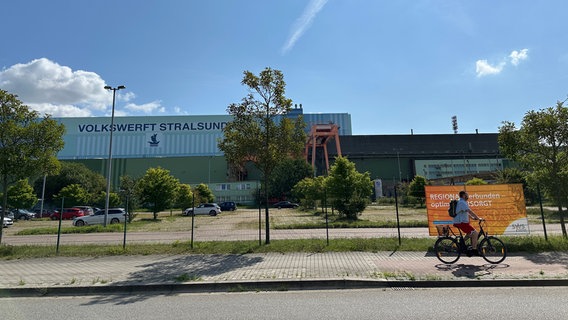 Auf dem Gelände der Stralsunder Volkswerft steht eine große Halle. Davor ist ein Parkplatz. © Mathias Marius Krüger Foto: Mathias Marius Krüger