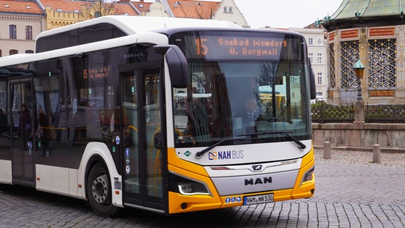 Ein weiß-gelber Bus des kommunalen Verkehrsbetriebes Nahbus fährt an der Wismarer Wasserkunst vorbei. © NDR Foto: Christoph Woest