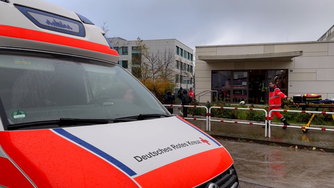 Rettungswagen und Rettungskräfte stehen vor einer Turnhalle in Neubrandenburg. 
