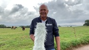 Thomas Globig präsentiert das Wetter auf der Insel Hiddensee vor einem Feld mit Pferden. © NDR Foto: NDR