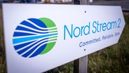 Ein Wegweiser steht vor der Erdgasempfangsstation der Ostseepipeline Nord Stream 2 im vorpommerschen Lubmin. © Jens Büttner/dpa 