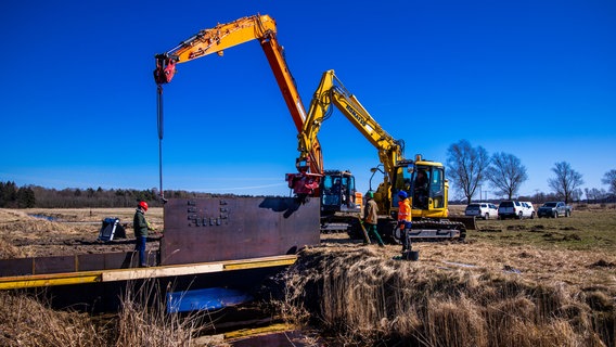 Bagger setzten in den Peenewiesen ein Kippwehr ein. © dpa Bildfunk Foto: Jens Büttner