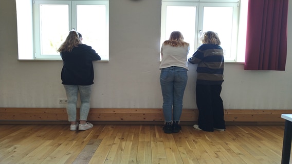 Drei Mädchen stehen mit dem Rücken zum Betrachter am Fenster. © NDR Foto: Christian Peplow