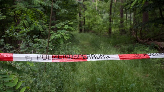 Symbolbild: Ein Absperrband mit der Aufschrift "Polizeiabsperrung" ist vor einem Waldweg befestigt. © picture alliance / Fotostand | Fotostand / K. Schmitt Foto: Fotostand / K. Schmitt