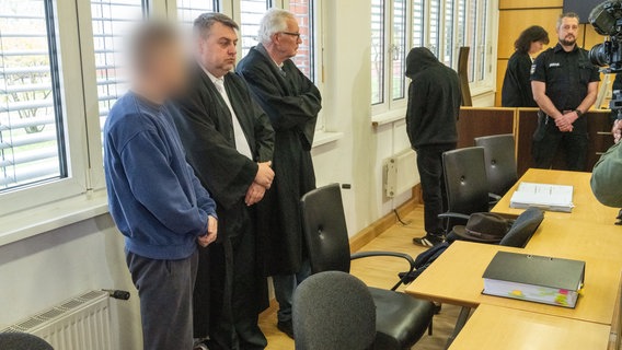 Die zwei Angeklagten (1. und 4. von links) stehen neben den zwei Verteidigern, Steffen Gerth (2.v.l) und Peter Hakert (3.v.l) vor Prozessbeginn im Sitzungssaal des Landgericht Stralsund. © dpa Foto: Stefan Sauer