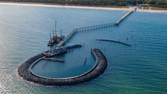 Blick auf die Seebrücke Prerow mit dem Inselhafen. Der Inselhafen wird den Nothafen auf der Halbinsel Fischland-Darß-Zingst ersetzen. Der vor zwei Jahr begonnene Bau der künstlichen Insel sowie der mit der zirka 720 Metern längsten Seebrücke im Ostseeraum soll am 16.10.2024 eröffnet werden. © dpa-Bildfunk Foto: Stefan Sauer/dpa