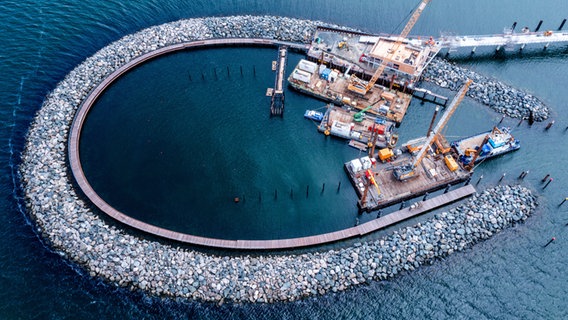 Auf der Baustelle des künftigen Inselhafens in der Ostsee sind Kräne und Bagger im Einsatz. (Luftaufnahme mit Drohne) Der Inselhafen wird den Nothafen auf der Halbinsel Fischland-Darß-Zingst ersetzen © dpa Bildfunk Foto: Jens Büttner