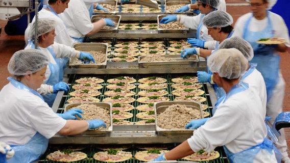 Mitarbeiterinnen belegen im Werk von Dr. Oetker in Wittenburg Tiefkühlpizzen © dpa - Bildfunk Foto: Bernd Thissen