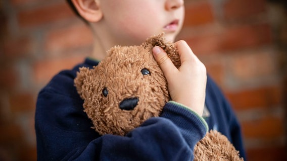 Ein Kind hält einen Teddybären im Arm. © picture alliance/photothek Foto: Thomas Trutschel