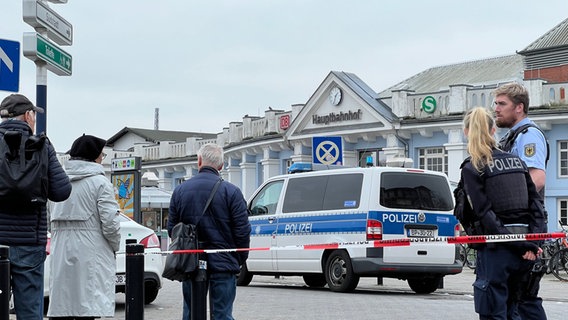 Polizisten und Passanten stehen vor dem Rostocker Hauptbahnhof. © NDR Foto: Jürn-Jakob Gericke