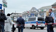 Polizisten und Passanten stehen vor dem Rostocker Hauptbahnhof. © NDR Foto: Jürn-Jakob Gericke