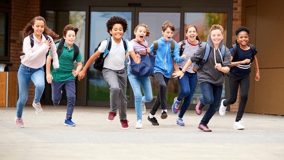 Kinder laufen happy aus der Schule. © IMAGO / Shotshop Foto: IMAGO / Shotshop