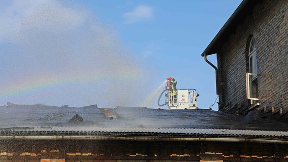 Ein Feuerwehrmann löscht einen Dachstuhlbrand. © Stefan Tretropp Foto: Stefan Tretropp