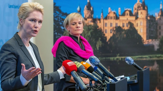 Manuela Schwesig (SPD, vorn), die Ministerpräsidentin von Mecklenburg-Vorpommern, und Simone Oldenburg (hinten), die Fraktionschefin der Partei Die Linke im Landtag von Mecklenburg-Vorpommern, geben nach einem Treffen zwischen SPD und Die Linken die Besetzung der zukünftigen Landesregierung bekannt. © dpa-Bildfunk Foto: Jens Büttner