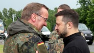 Boris Pistorius (SPD, l), Bundesverteidigungsminister, und Wolodymyr Selenskyj, Präsident der Ukraine, begrüßen sich bei ihrem Besuch auf einem Truppenübungsplatz in Mecklenburg-Vorpommern. © dpa-Bildfunk Foto: Jens Büttner