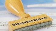 Ein Stempel mit dem Schriftzug "Steuerschätzung" liegt auf einem Dokument. © picture alliance / Zoonar Foto: ANDREAS PULWEY