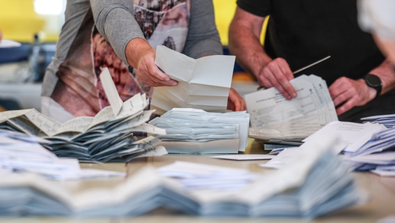 Zahlreiche Wahlhelfer sind mit der Stimmenauszählung der Briefwahlstimmen zur Europawahl beschäftigt. © Jan Woitas/dpa Foto: Jan Woitas/dpa