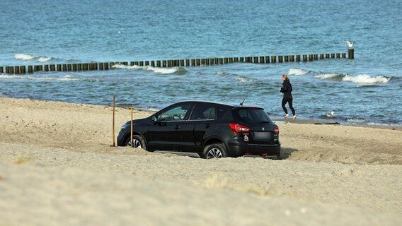 Ein Auto hat sich am Ostseestrand neben der Seebrücke Graal-Müritz (Landkreis Rostock) festgefahren. © Stefan Tretropp Foto: Stefan Tretropp