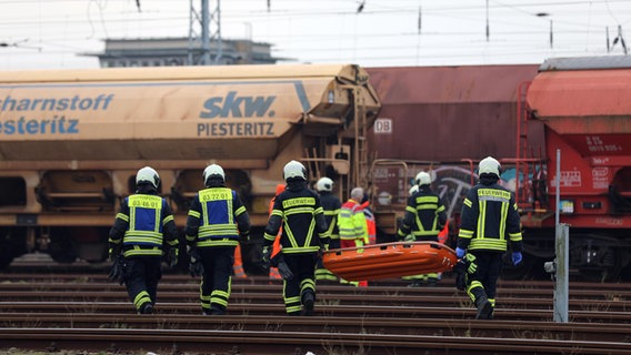 Feuerwehrleute bergen einen Toten auf dem Güterbahnhof am Rostocker Überseehafen. © Stefan Tretropp Foto: Stefan Tretropp