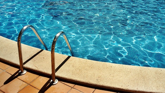 Ein Swimmingpool mit einer Leiter die ins blaue Wasser führt. © photocase Foto: Frau Locke