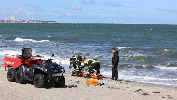 Rettungskräfte stehen am Strand von Markgrafenheide. © NDR Foto: Stefan Tretropp