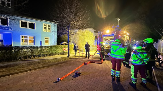 Feuerwehrleute stehen neben einem Feuerwehrfahrzeug bei einem Einsatz in Zinnowitz. © Tilo Wallrodt 