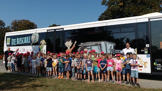 Grundschüler aus Steinhagen stehen vor einem Bus mit der Aufschrift "Die Busschule". © Polizei Stralsund 