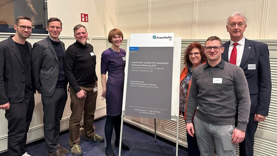 Mehrere Menschen stehen vor einem Schild mit der Aufschrift "Fraunhofer-Institut für Graphische Datenverarbeitung IGD" © NDR Foto: Mathias Marius Krüger