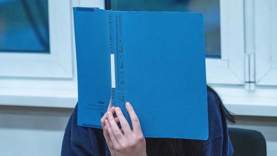 Die Hauptangeklagte sitzt mit Handschellen im Gerichtssaal am Landgericht Stralsund. © Stefan Sauer/dpa 